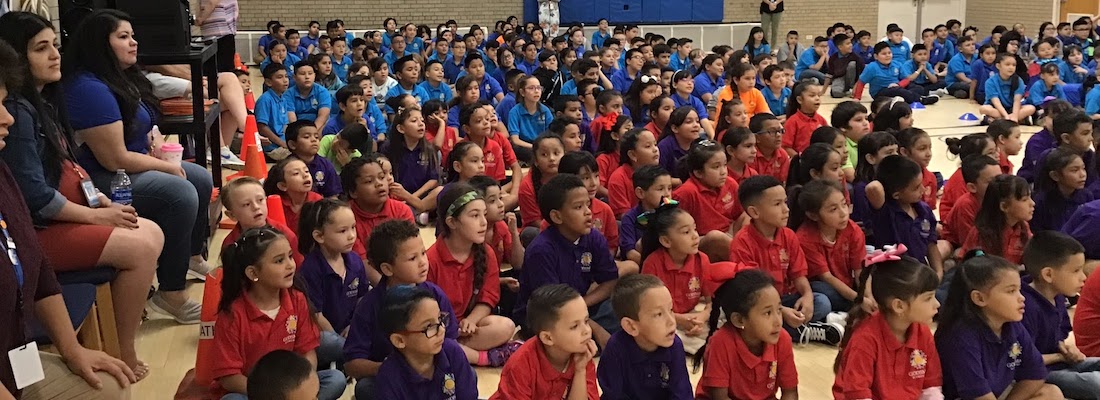 All school students sitting on the gym floor