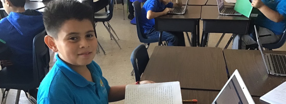 Student posing with notebook and laptop